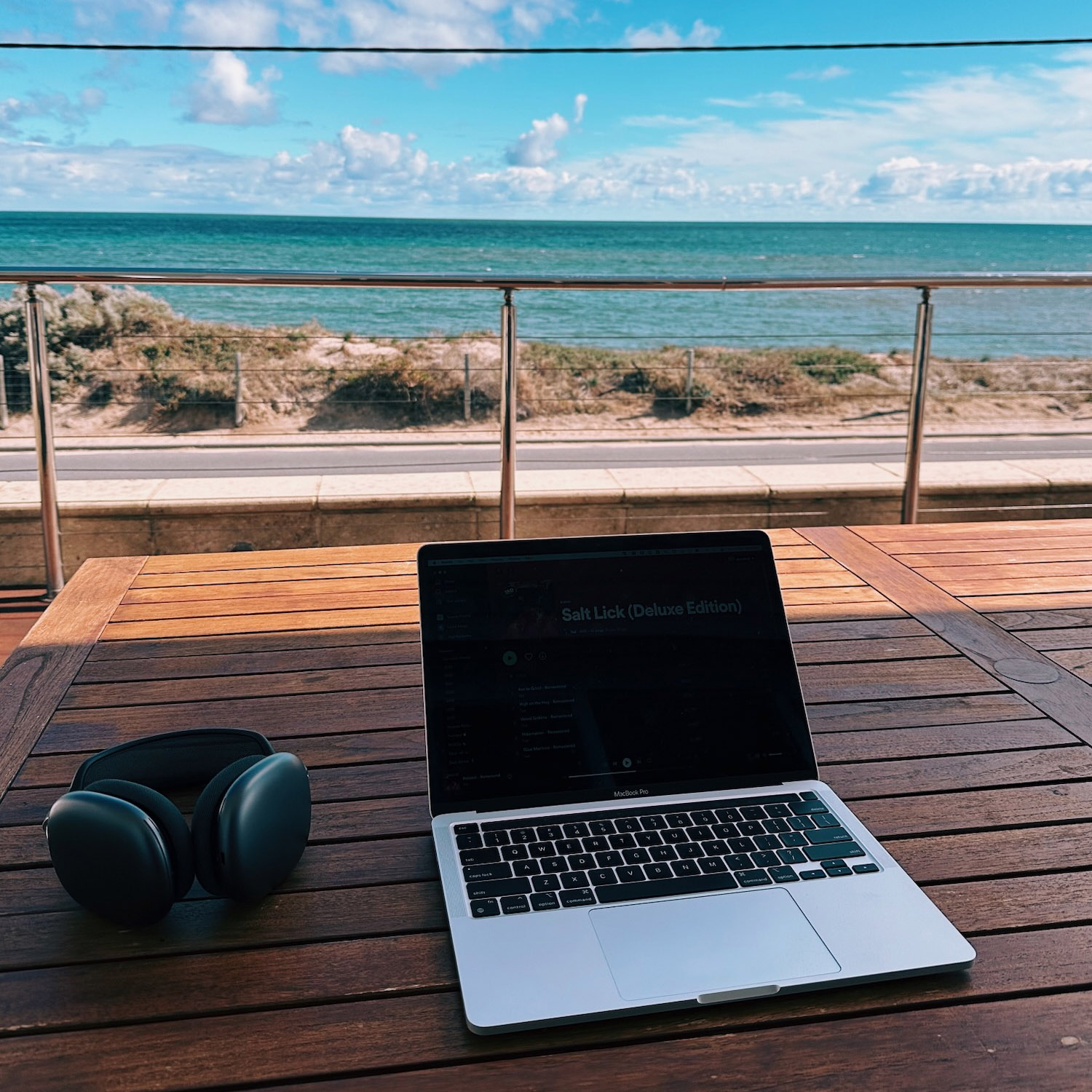 A laptop on a table overlooking the ocean