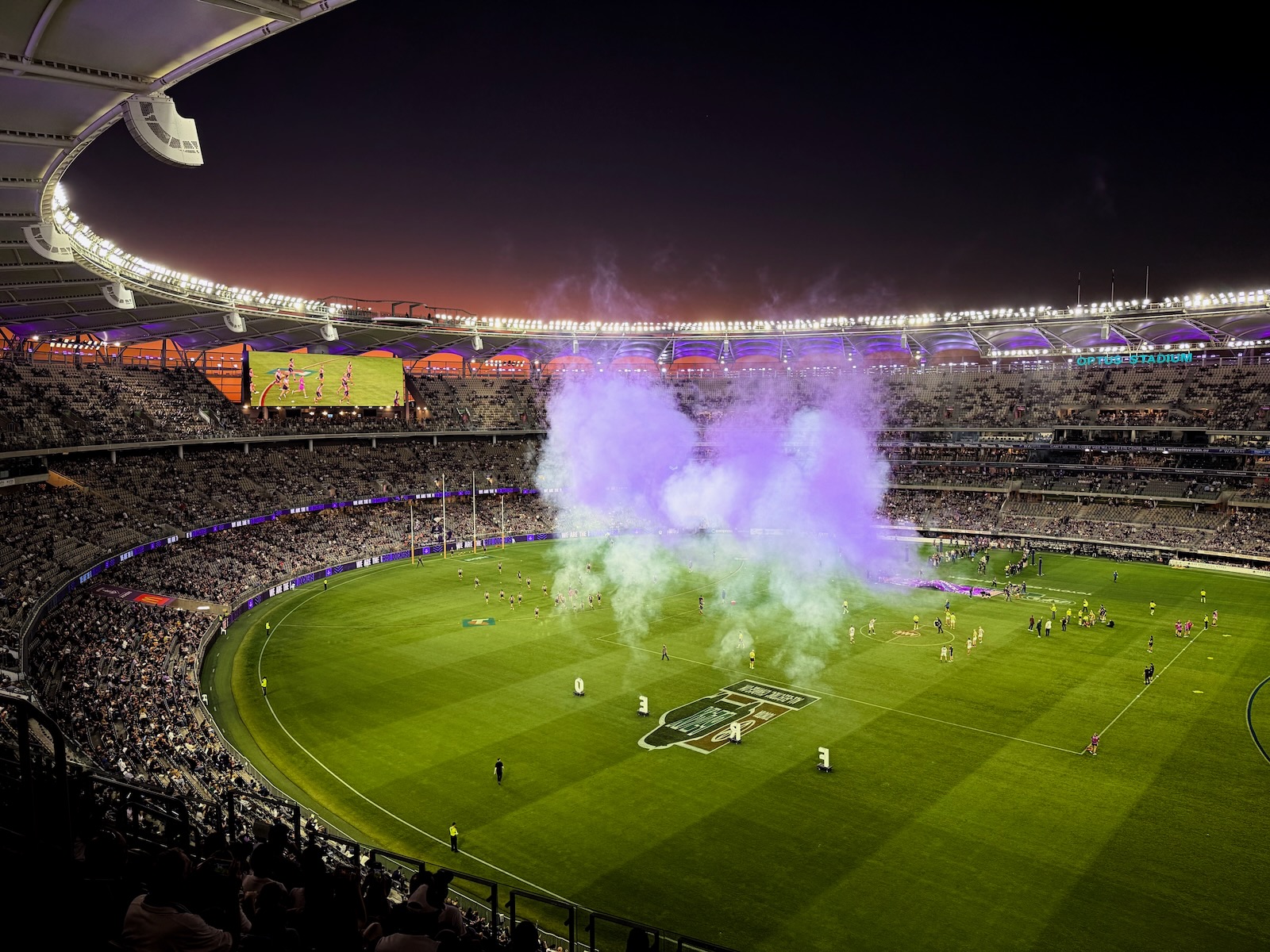 A plume of purple smoke over Optus Stadium