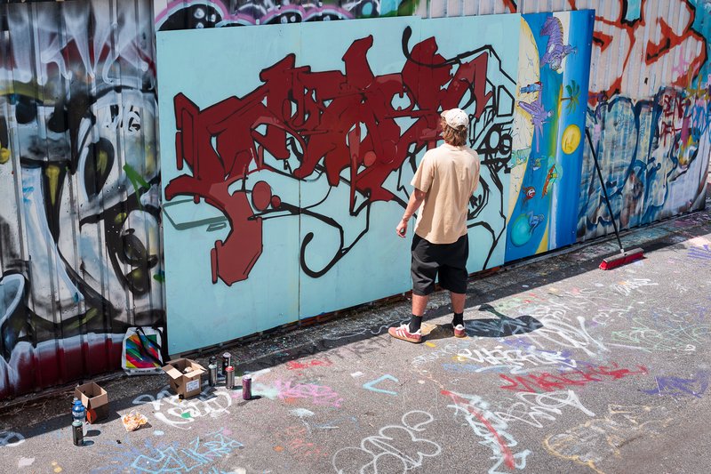 Man standing in front of a wall of street art.